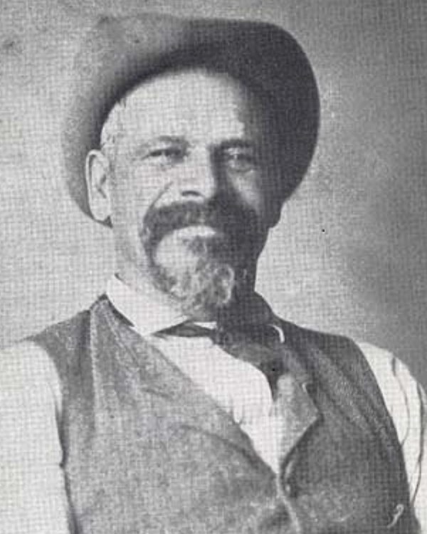 Portrait of Peter Bruner wearing a white shirt, vest, and hat.