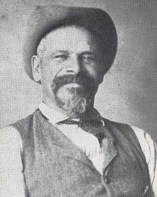Portrait of Peter Bruner wearing a white shirt, vest, and hat.