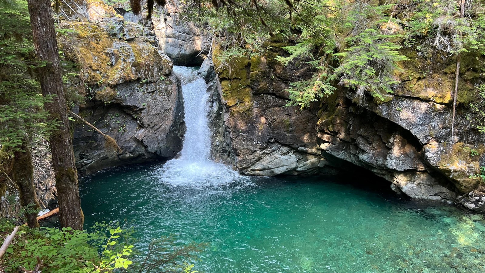 30 foot waterfall that drops into clear blue green plunge pool