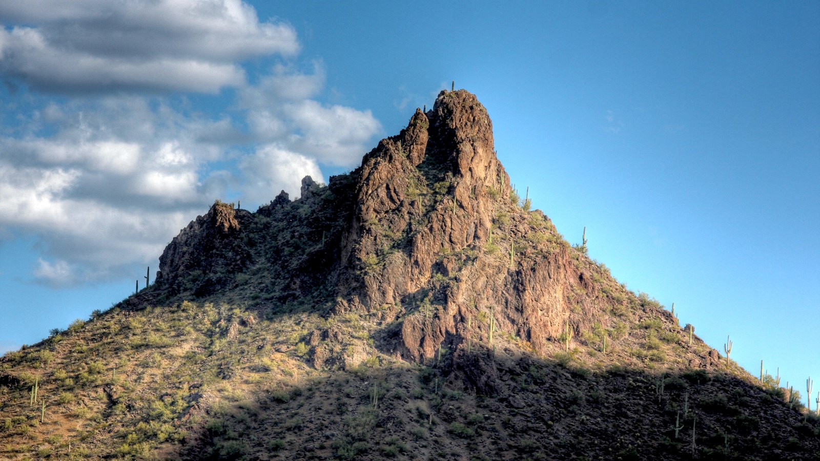 A prominent and jagged rock peak against a clear sky