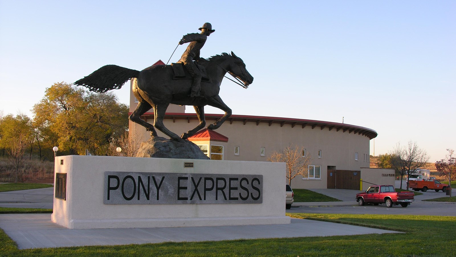 A large Pony Express statue of a galloping horse and rider faces to the right atop a large base.