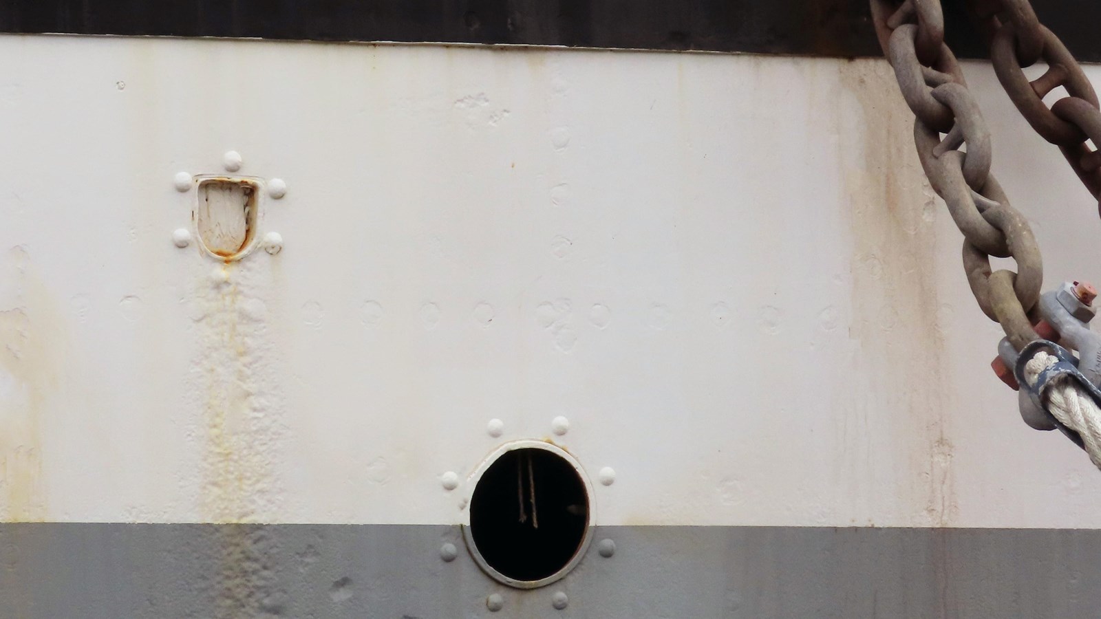 Three holes in the hull on Balclutha of different shapes and sizes.