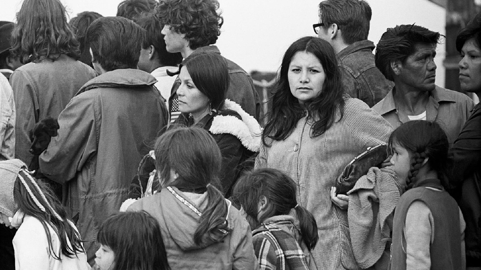 Black and white photograph of protestors and their families gathered on the dock.