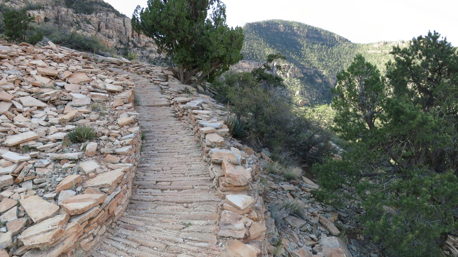 A trail constructed of meticulously placed slabs of rock winds its way down into Grand Canyon.