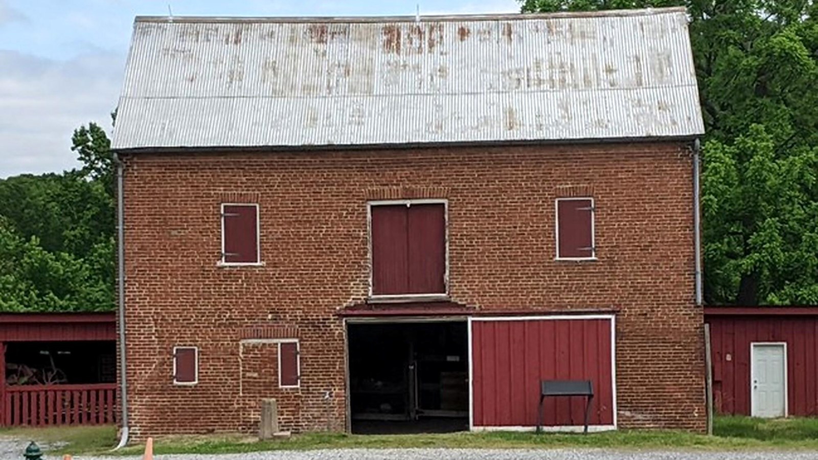 A two story brick building with rusted metal roof.
