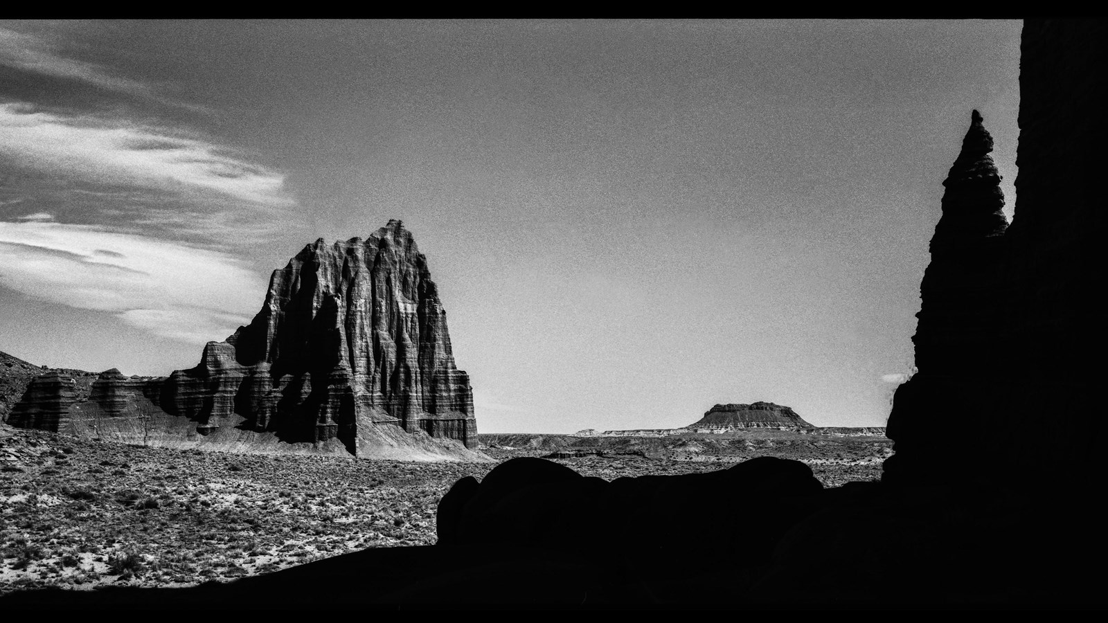 Large format black and white photo of a large sandstone monolith. 