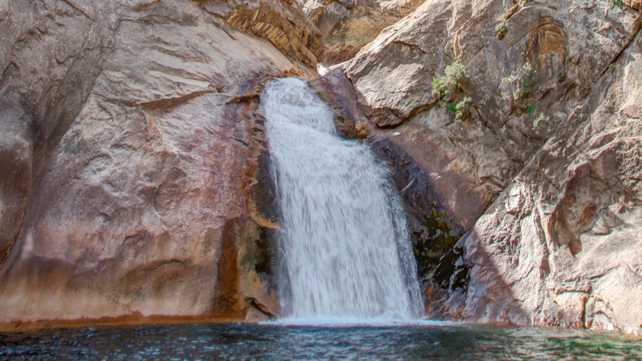 A large waterfall pumps water out into a pool.