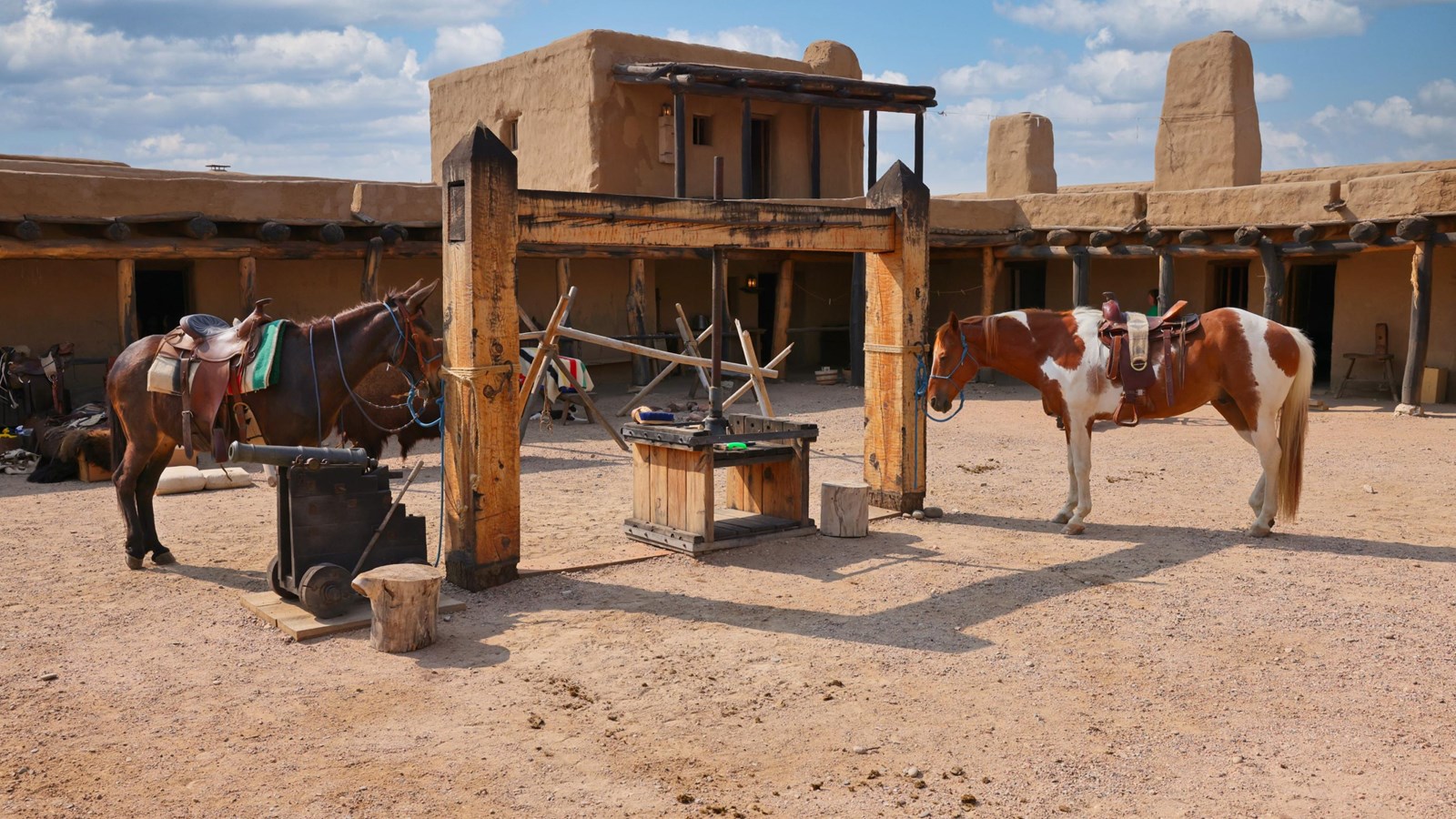 Horse and Mule Hitched to the Fur Press in the center of an adobe fort.
