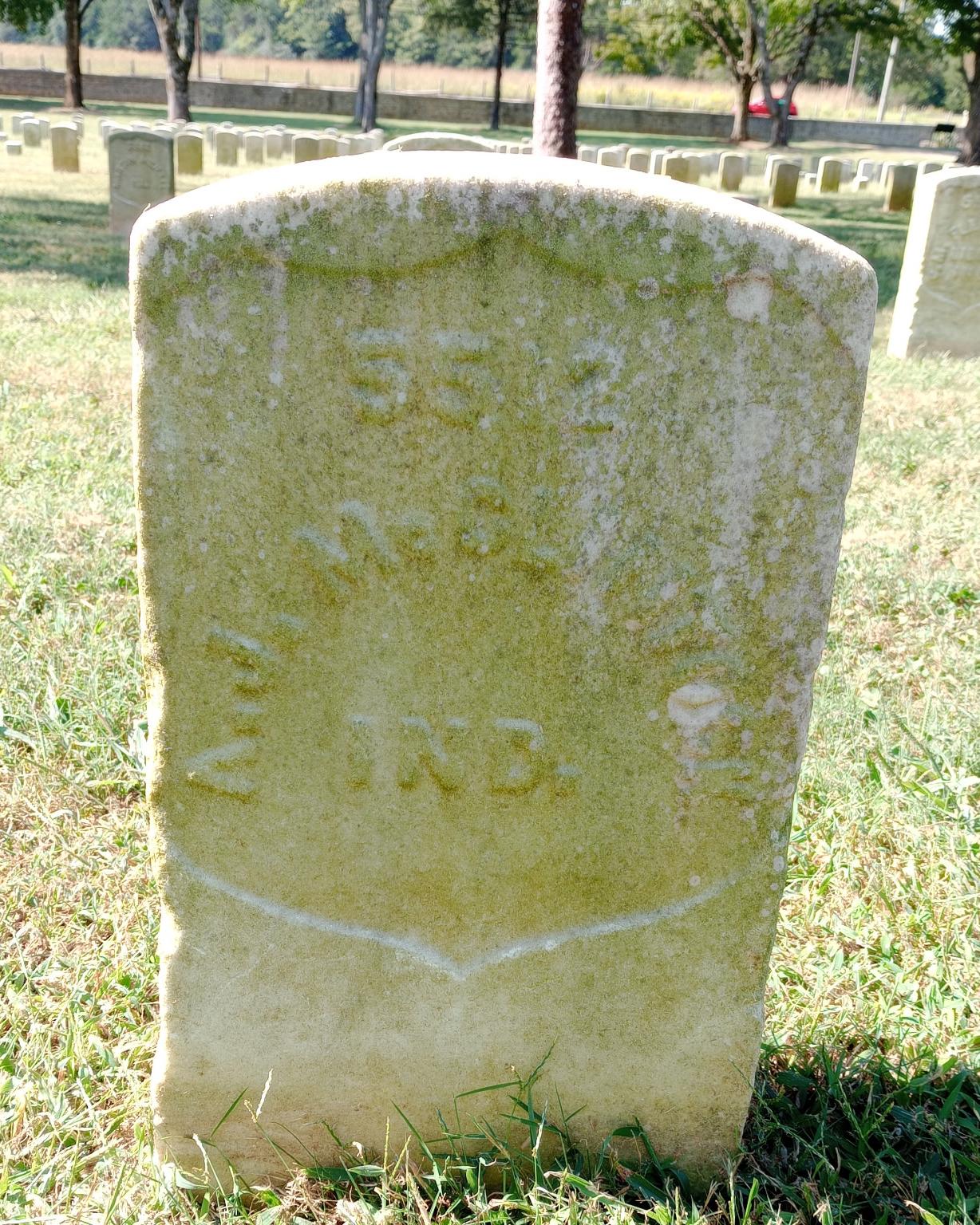 Marble headstone with faint letters that read A.J. McClintock.