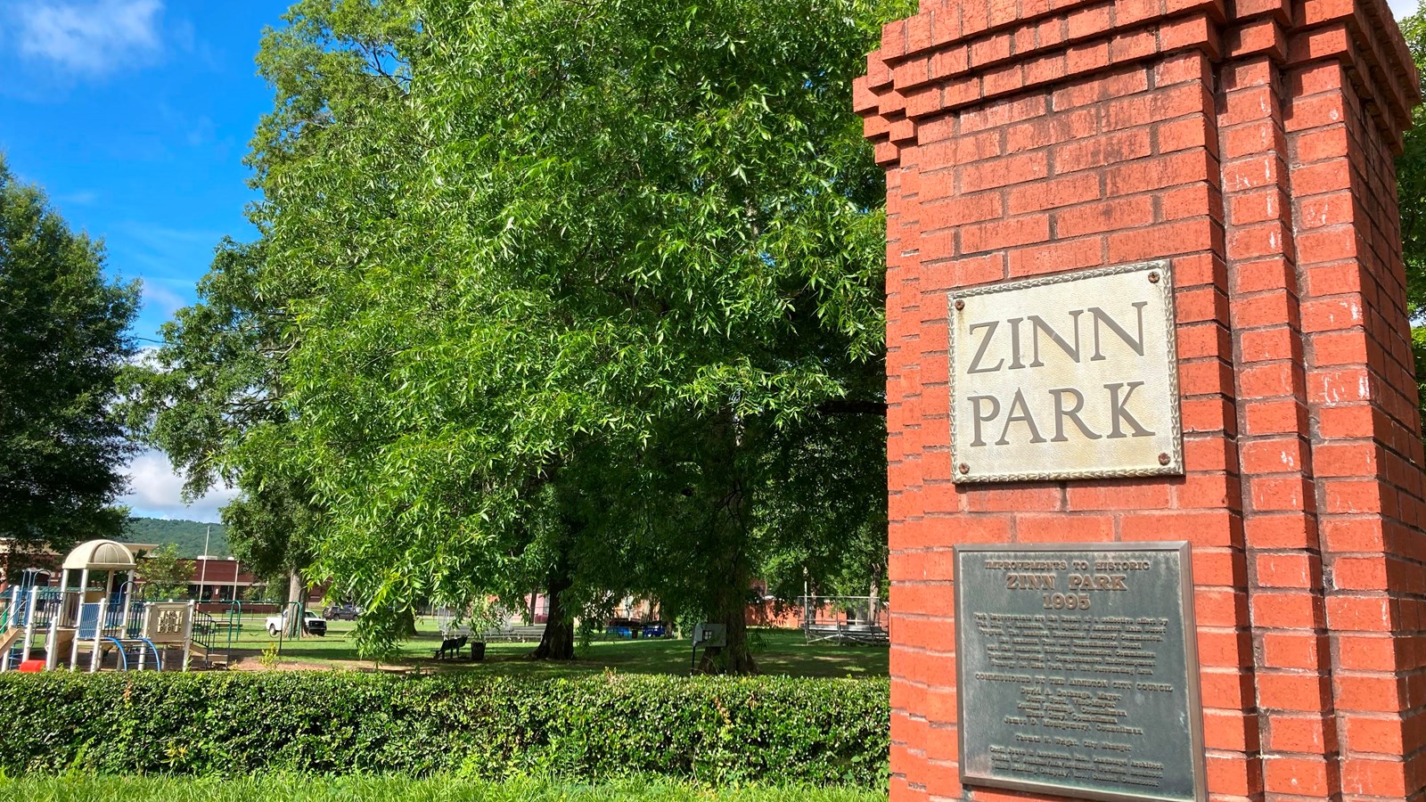 Foreground: a red-brick pillar says