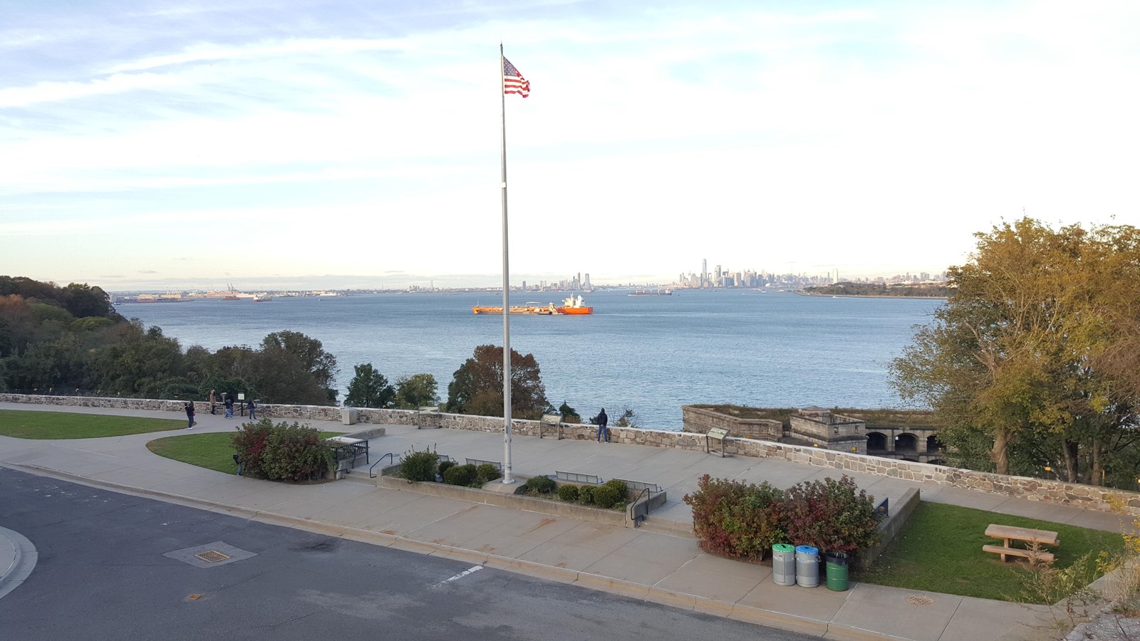 Site with flag overlooking NY Harbor flanked by trees