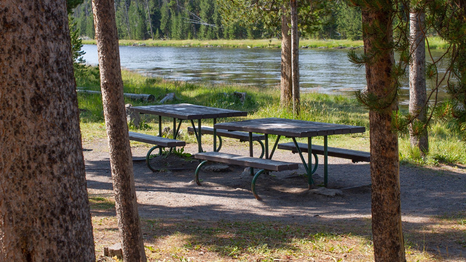 A picnic table in the forest near a large stream