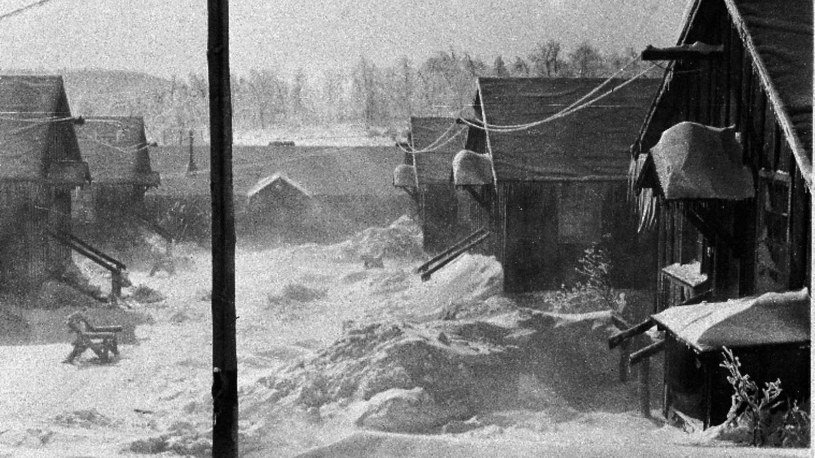  A winter day in a CCC camp. Snow covers the ground on the “Company Street” with large snow drifts.
