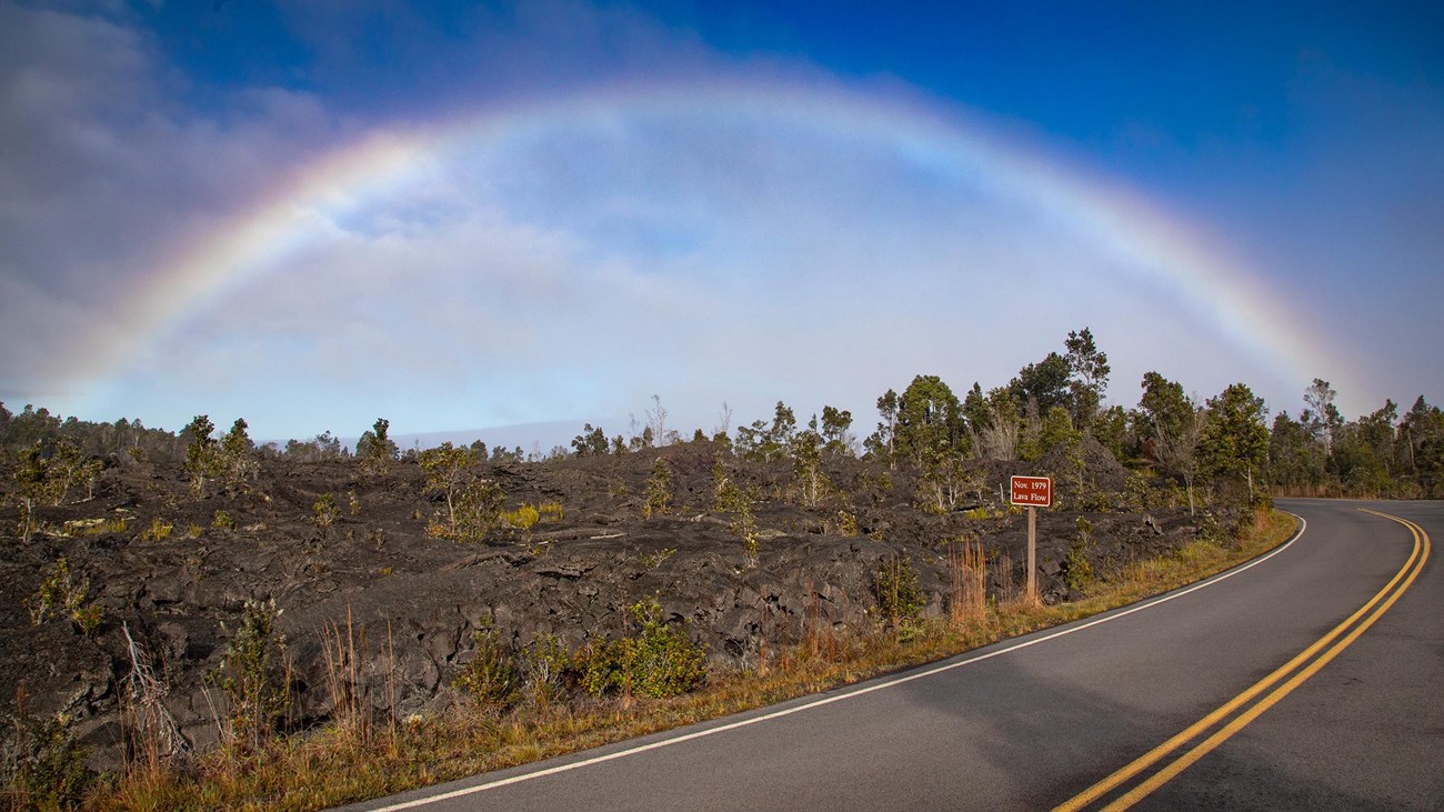 Rainbow on the side of a road in a lava landscape