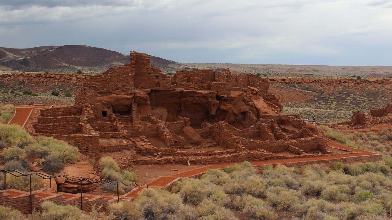 A multi-room sandstone structure without a roof. 