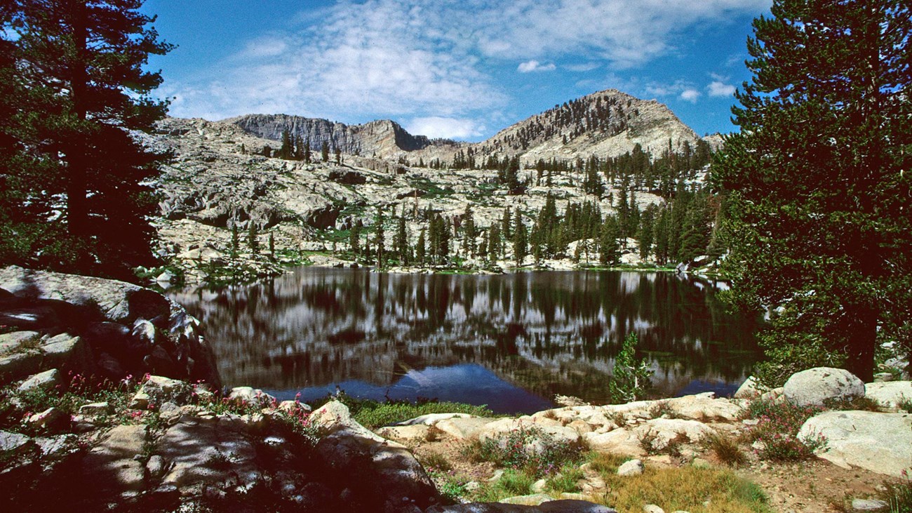 A large lake surrounded by forest covered granite walls.