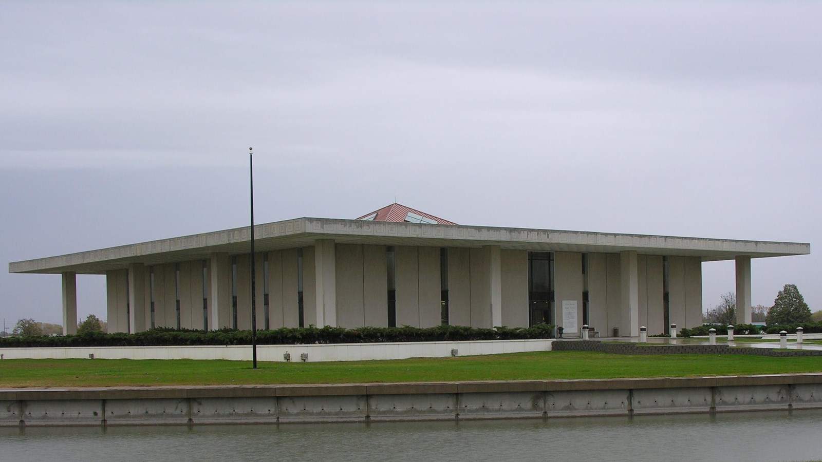 A rectangular building sitting in the middle of a lake