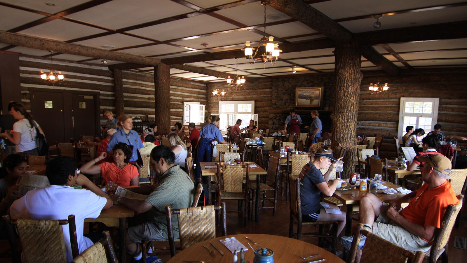 People sit at tables in a rustic dining room