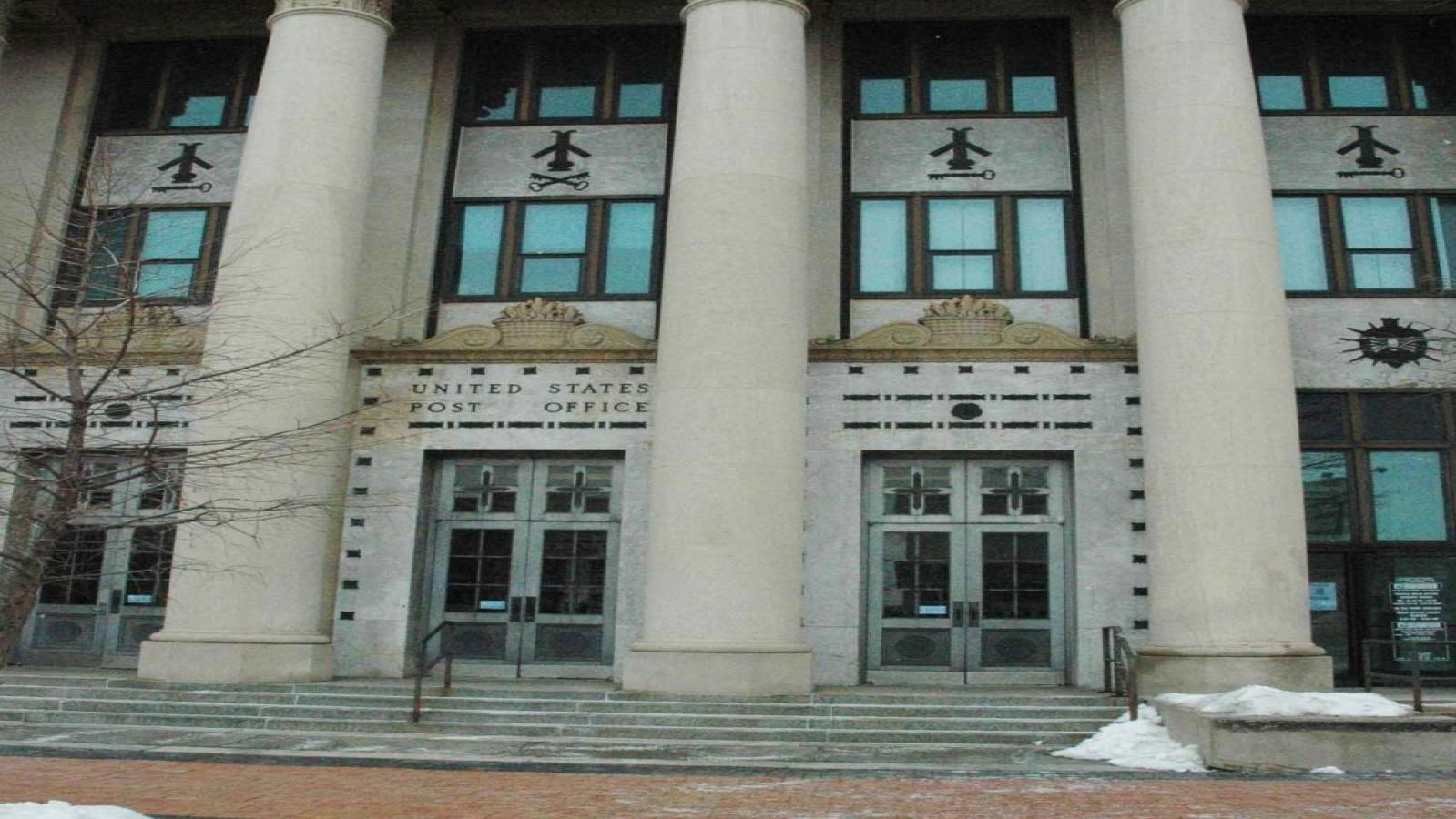 A grey 3-story building with three concrete pillars and three entrances are visible.