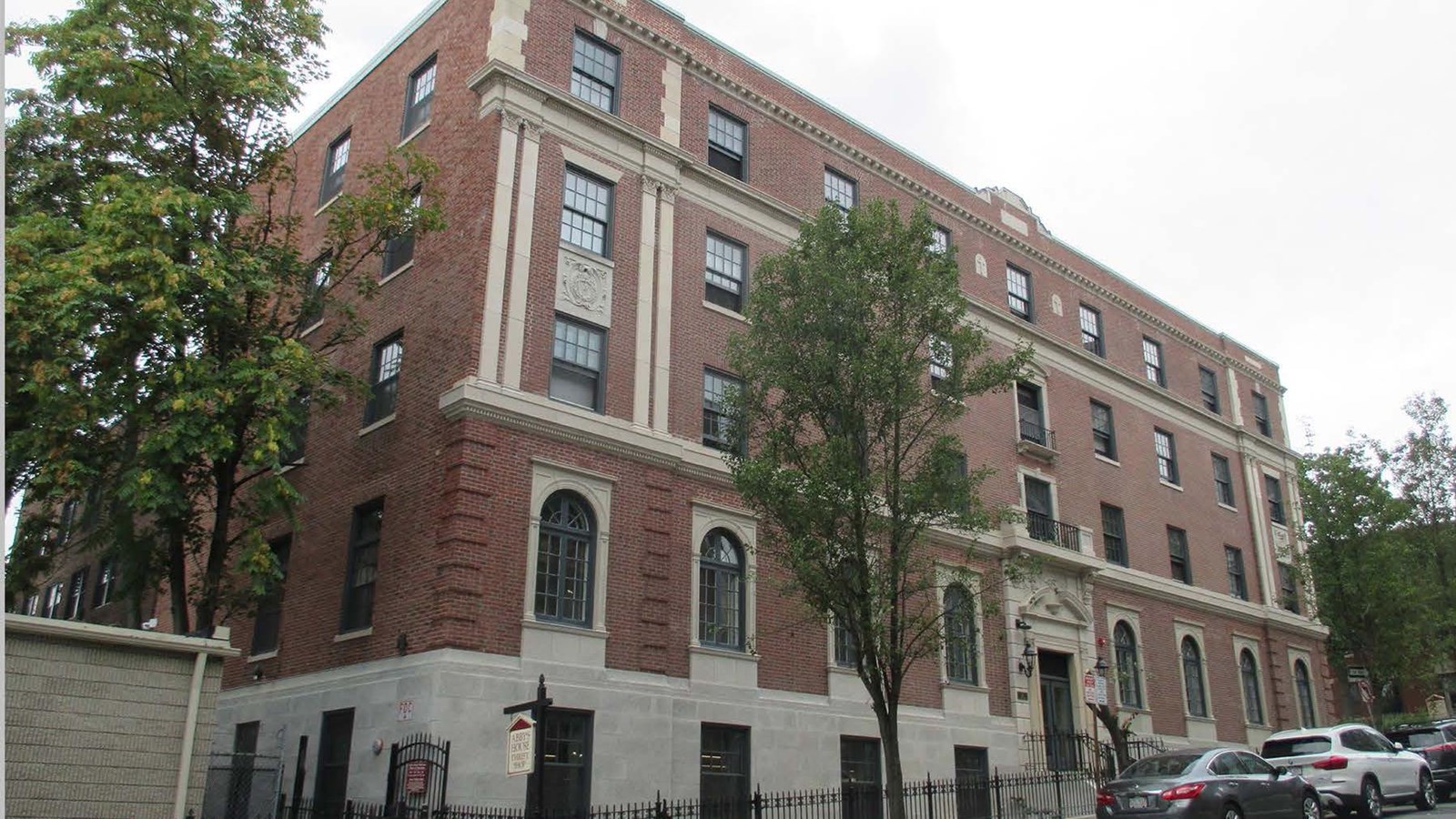 A five-story red brick Georgian Revival-style building on street corner