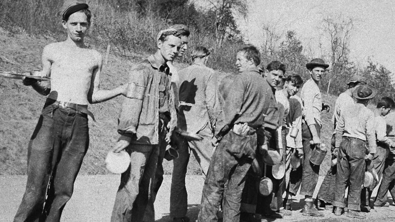 A CCC work crew waits eagerly in line to be served their hot noon meal.