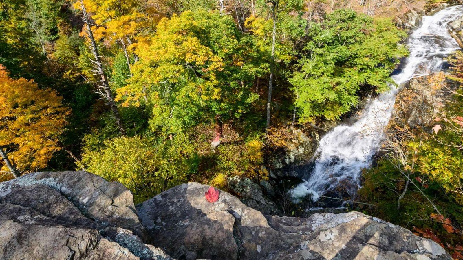 A color photograph of swift cascades from atop a rocky outcrop.