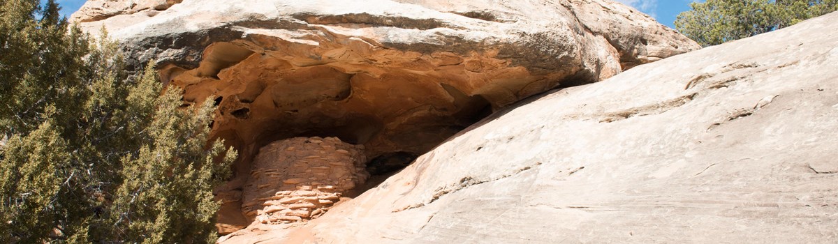 a small stone structure beneath a rock alcove