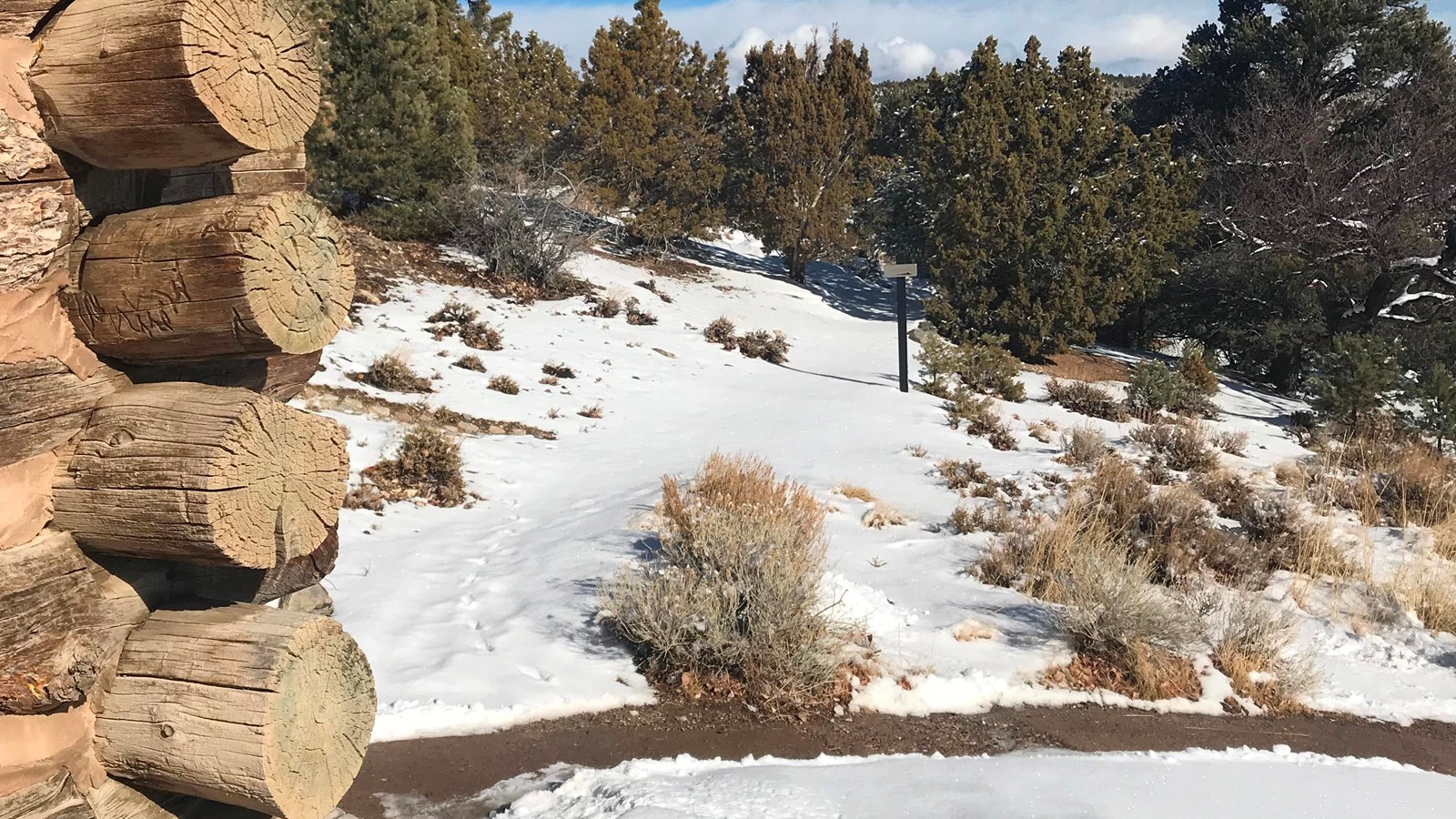 Snow covered trail with historic in foreground.