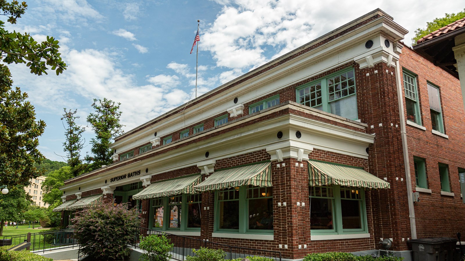 Superior Bathhouse is a wide brick building with green framed windows