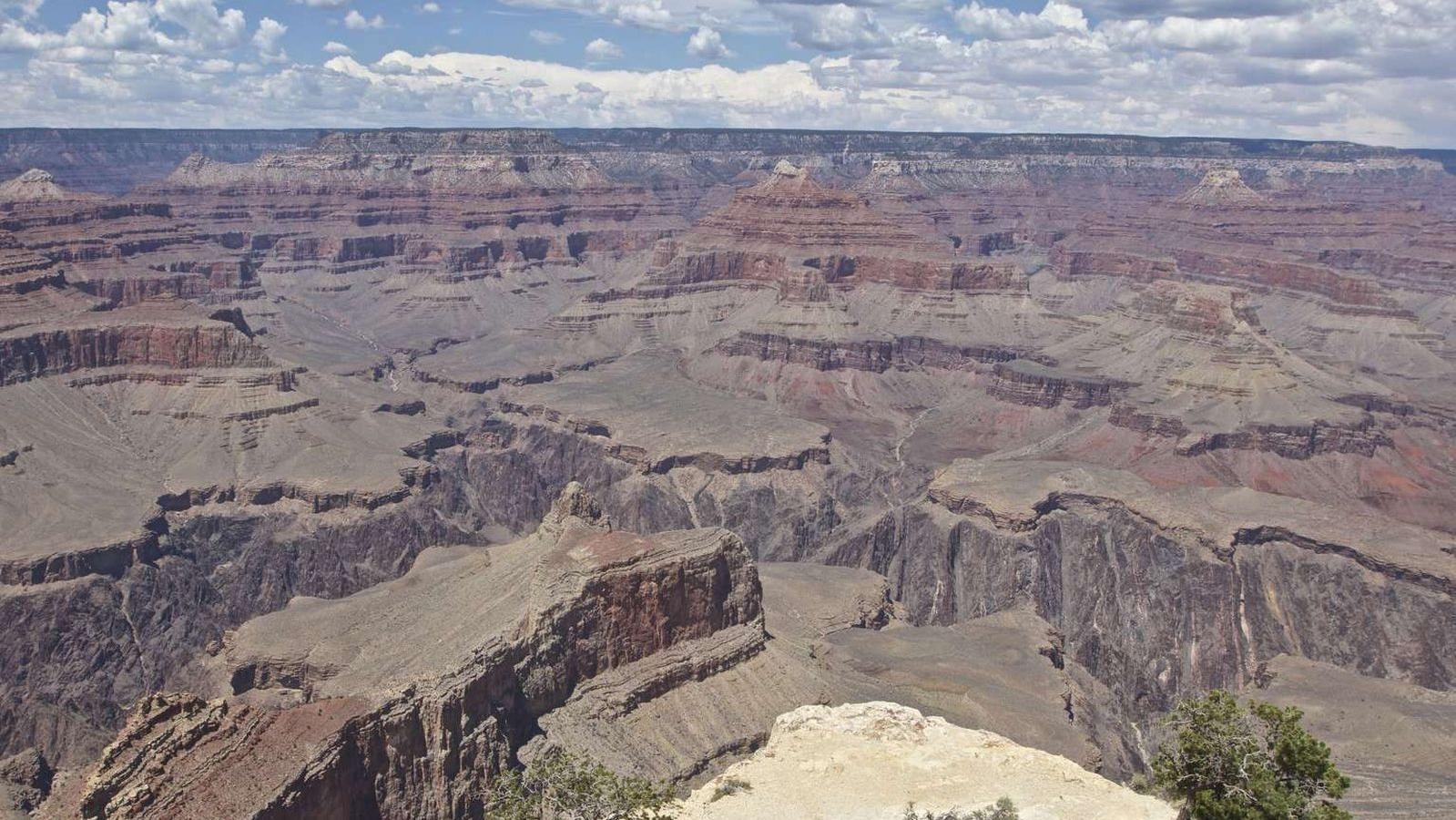 A small platform of rock extends out into a vast canyon landscape