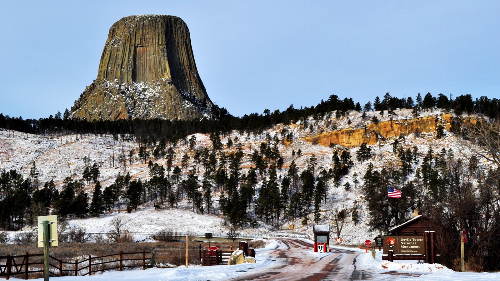 Devils tower in background american flag and entrance station