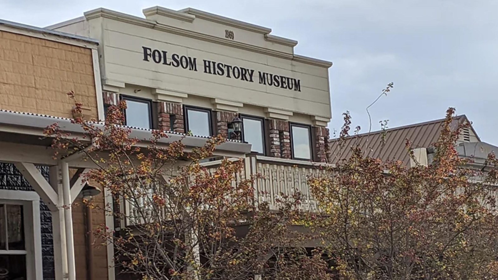 1900s historic building with wooden awning and second story windows.