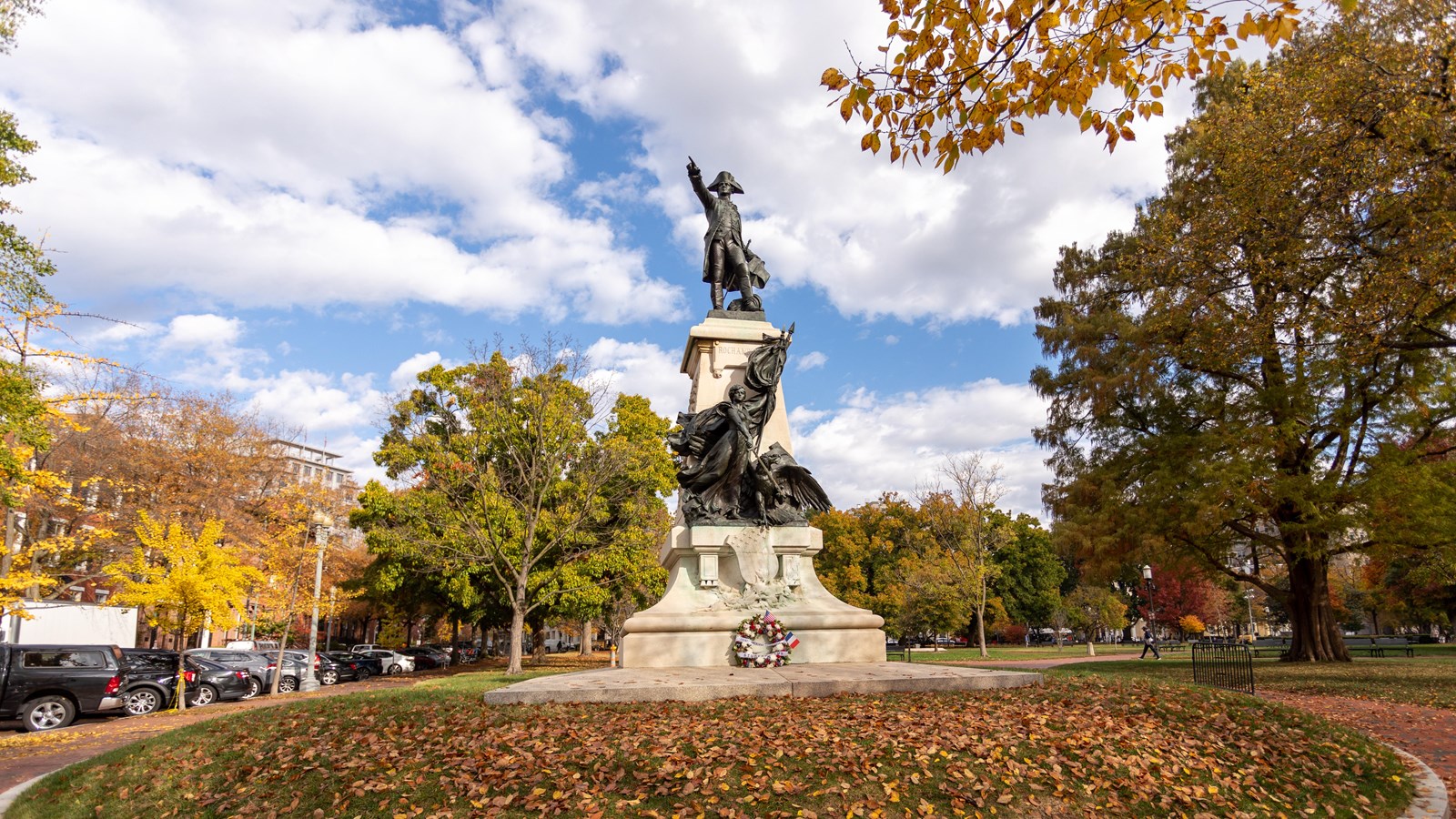 A bronze statue of a man in Revolutionary clothing pointing outward, standing on an plinth.