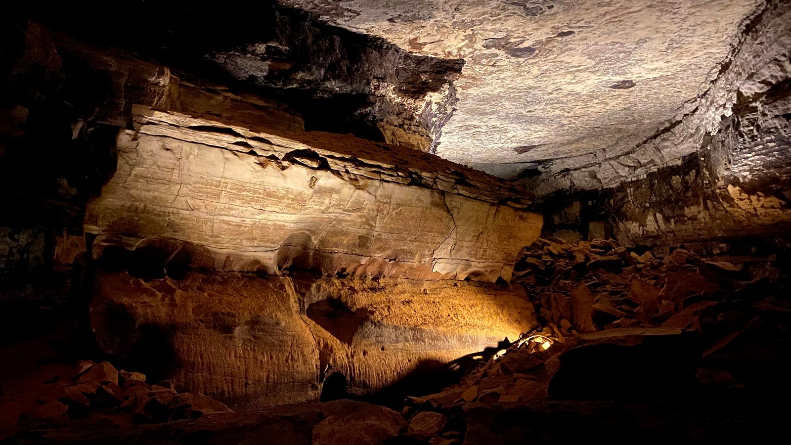 A large rock in the shape of a coffin in a large cave passage.