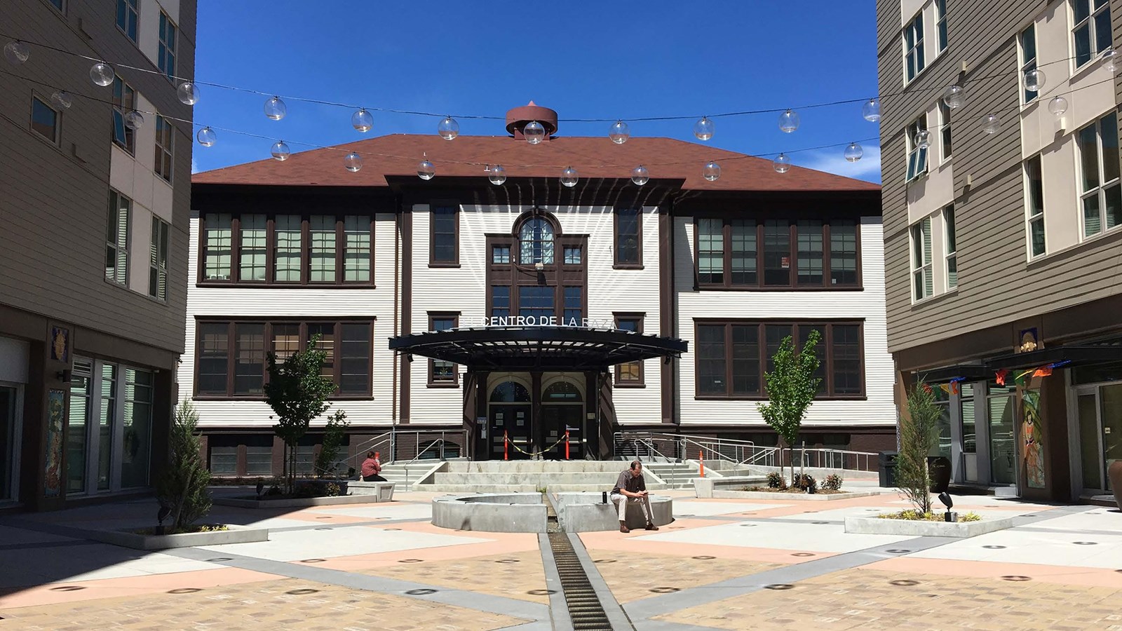 Entrance to a two story building with large windows on both wings. 