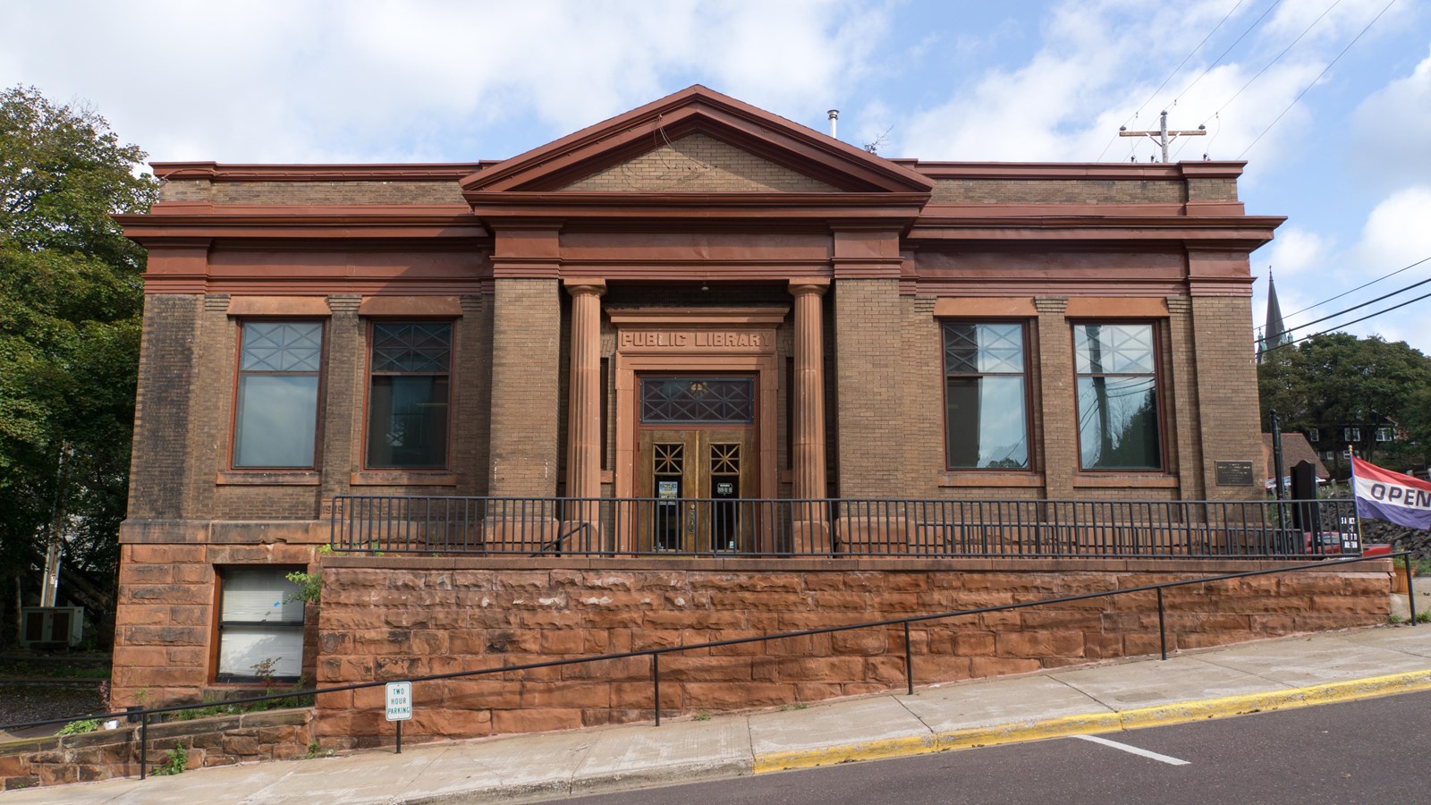brick building with red sandstone foundation. A sign above the main entrance reads: public library.