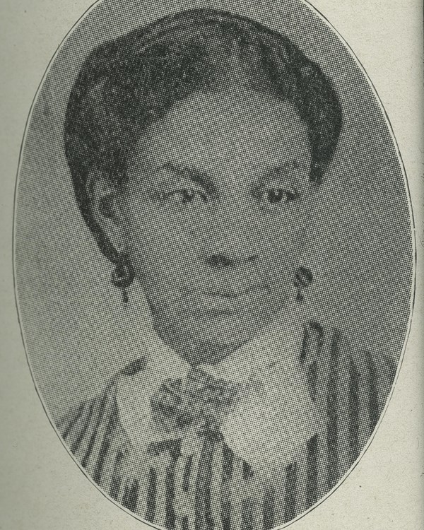 Head and shoulders portrait of a woman wearing a striped dress.