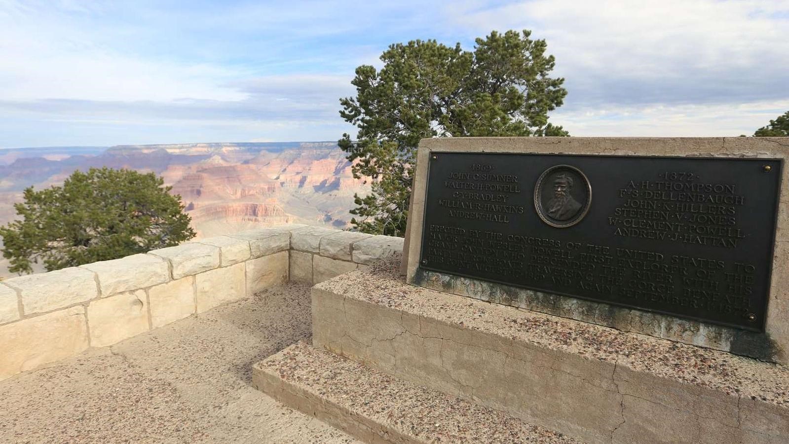 A large dark brown bronze plaque rests in a large block of white limestone.