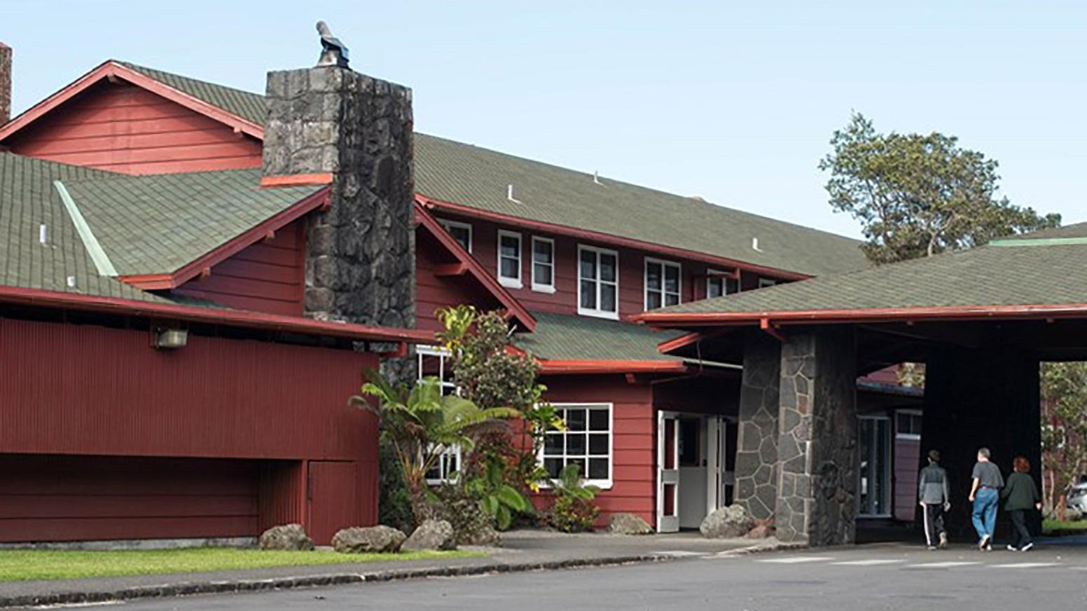 Front of a large red building with a drive way and covered entrance.