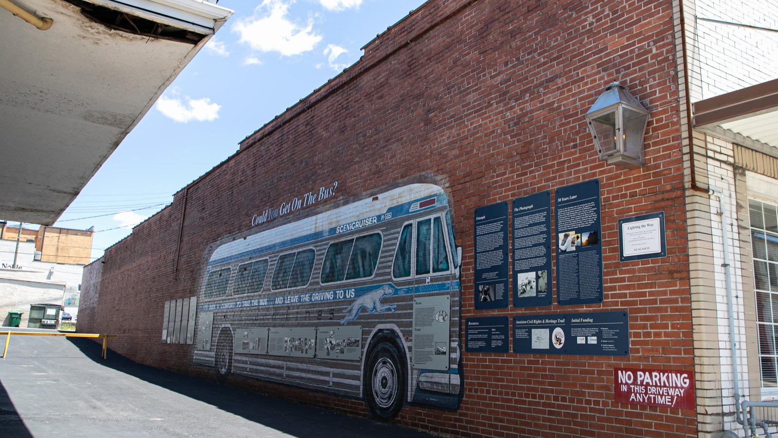 A large silver mural depicting a Greyhound bus facing an empty alleyway