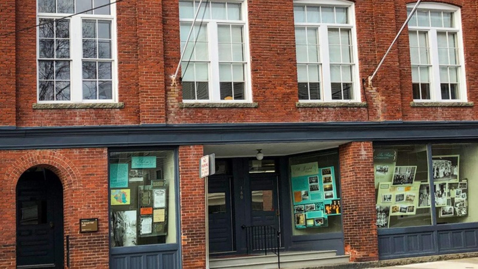 Three-story brick building with display windows on first floor and rows of windows on floors above