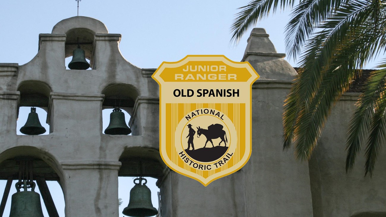 A junior ranger badge on an picture of a historic Spanish mission