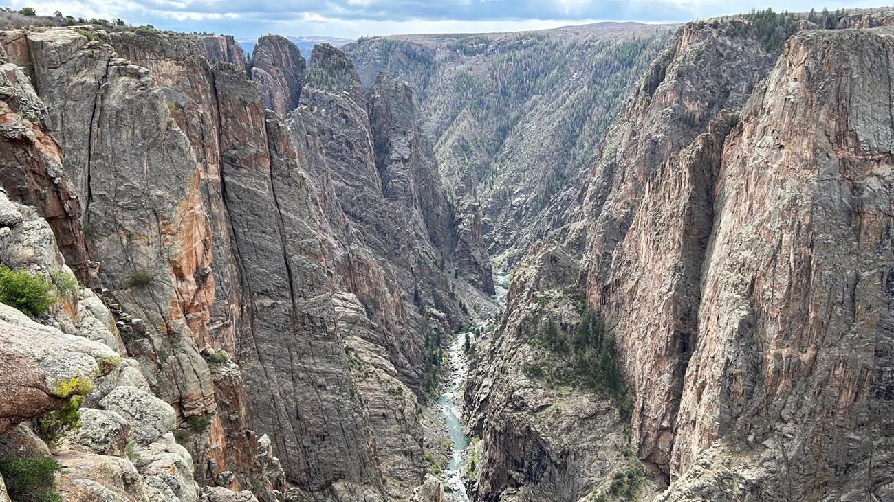 A steep canyon with vertical walls and a river at the bottom