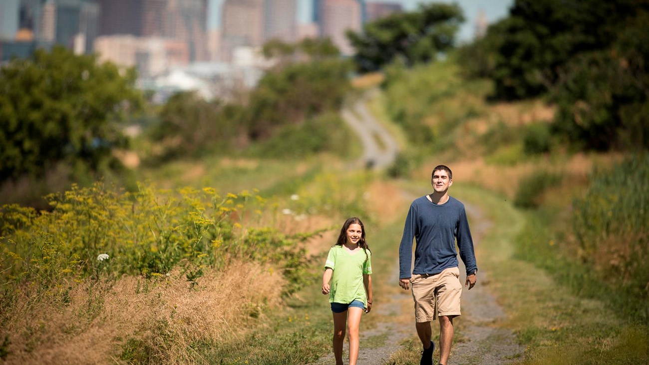 two people walking on a trail on Spectacle Island.