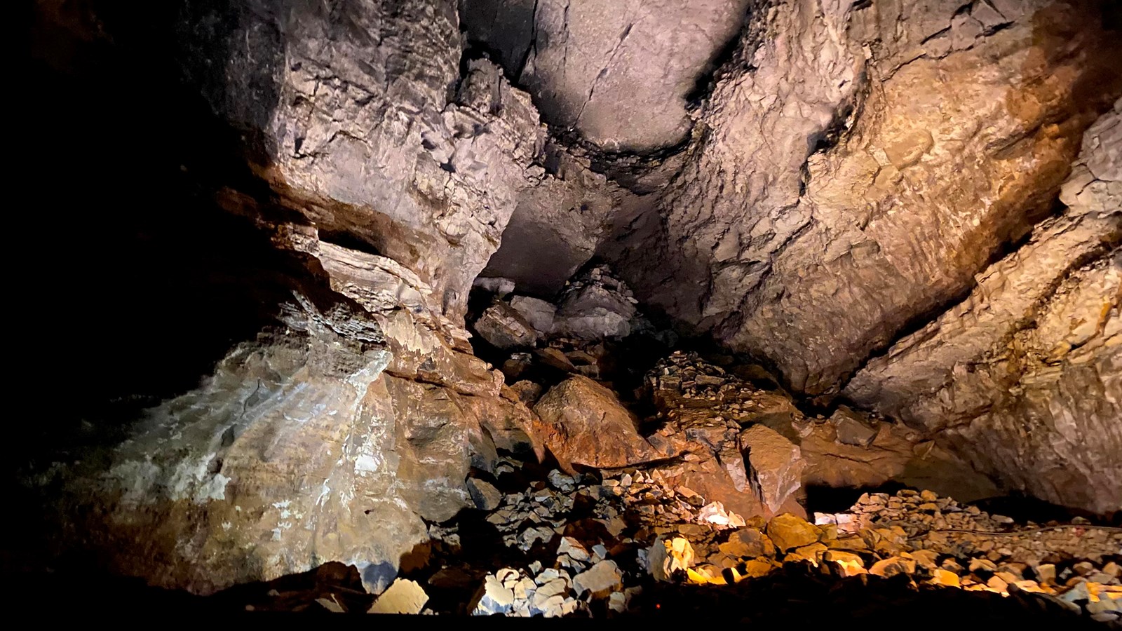 A cave room with a large area of rock breakdown. 