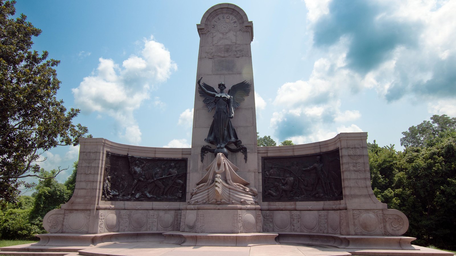 A front view of the Missouri monument\'s frontside with blue sky and white clouds.