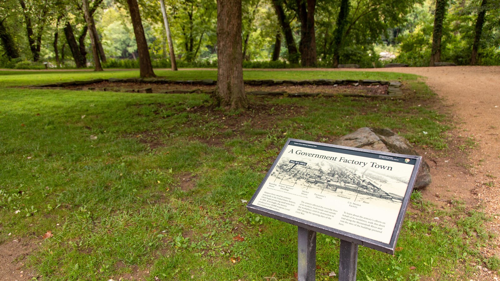 Exhibit panel near a stone foundation.