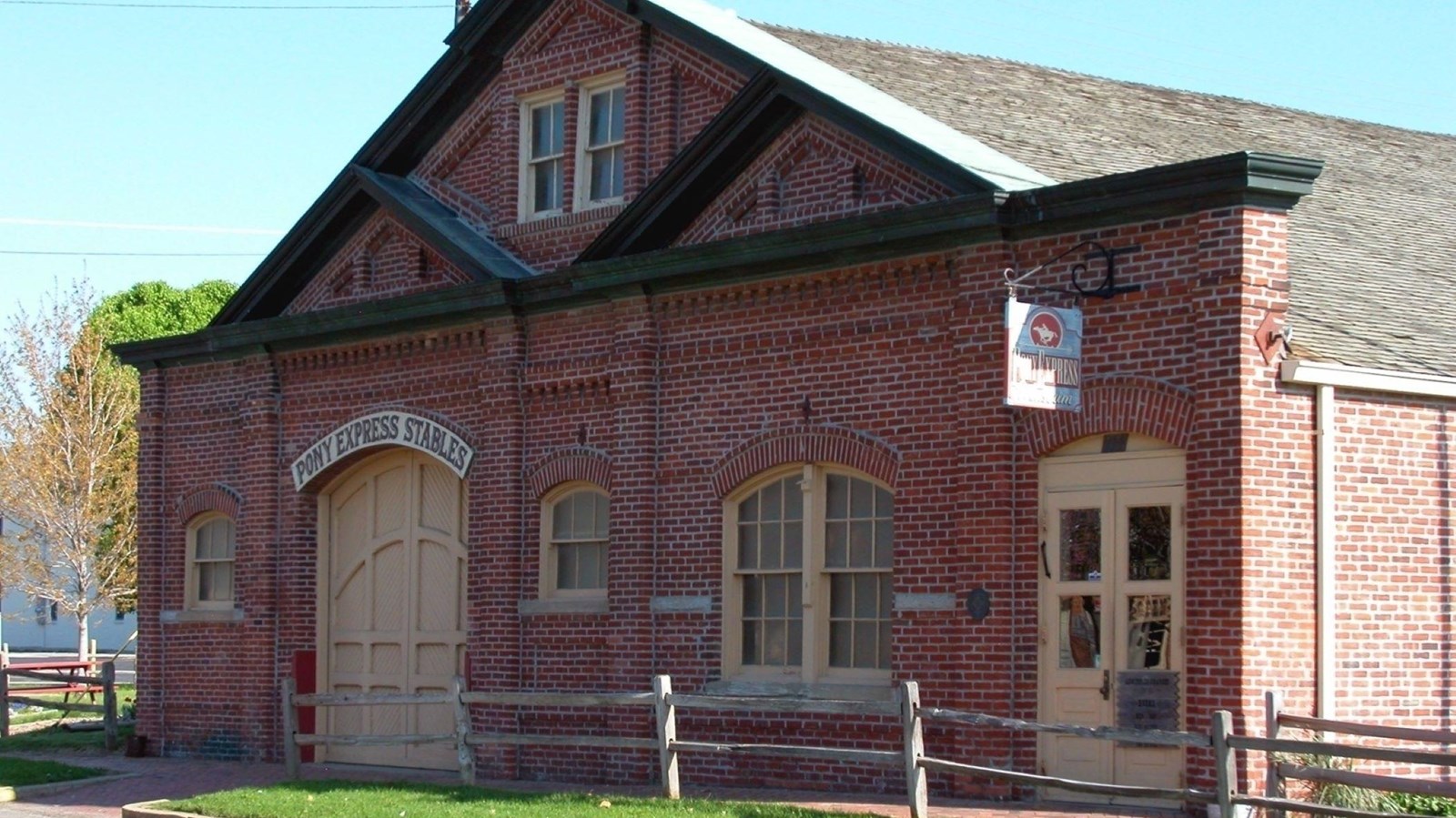 A red-brick barn with a large barn door and