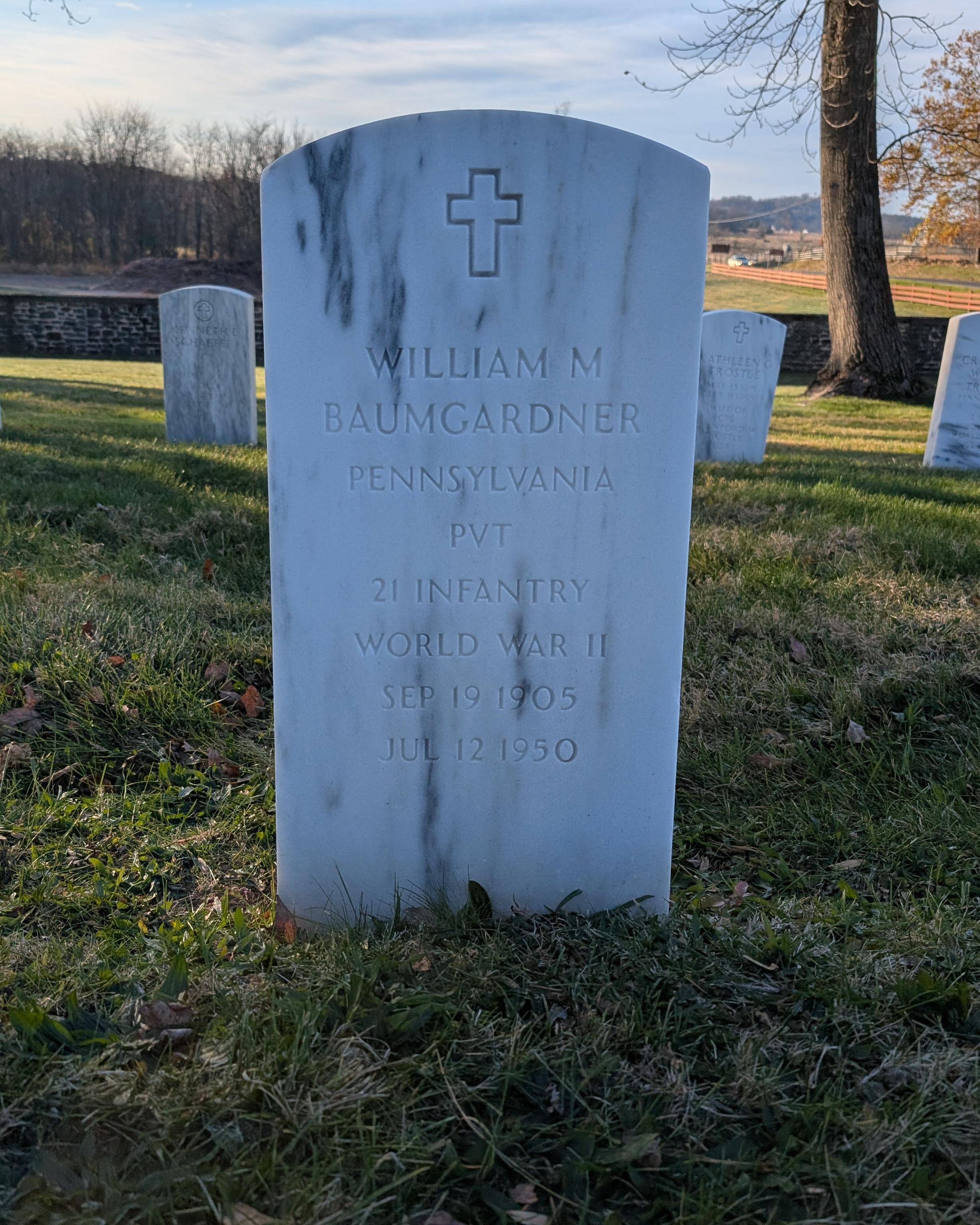 A white marble headstone for William Baumgardner