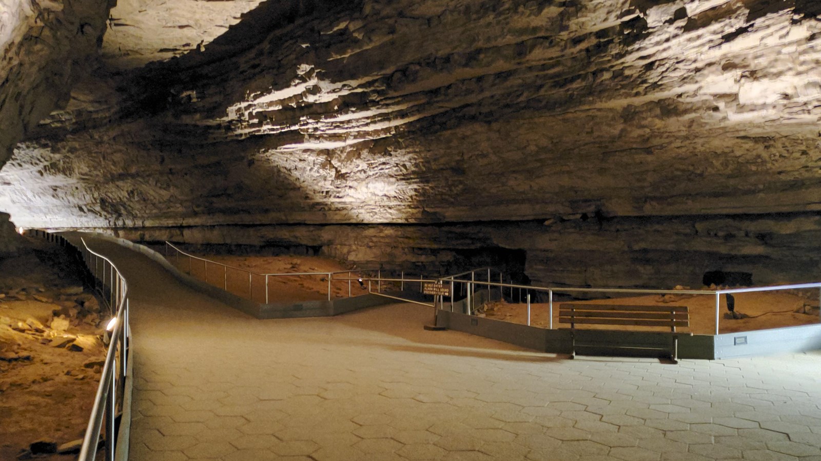 A large cave passage with a concrete tile floor.